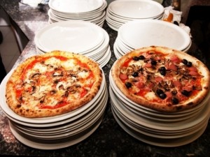 Pizzeria Da Cristina - best pizza in turin with image of two large pizzas on a plate 