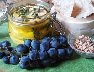 cup of cheese with herbs and bunch of grapes