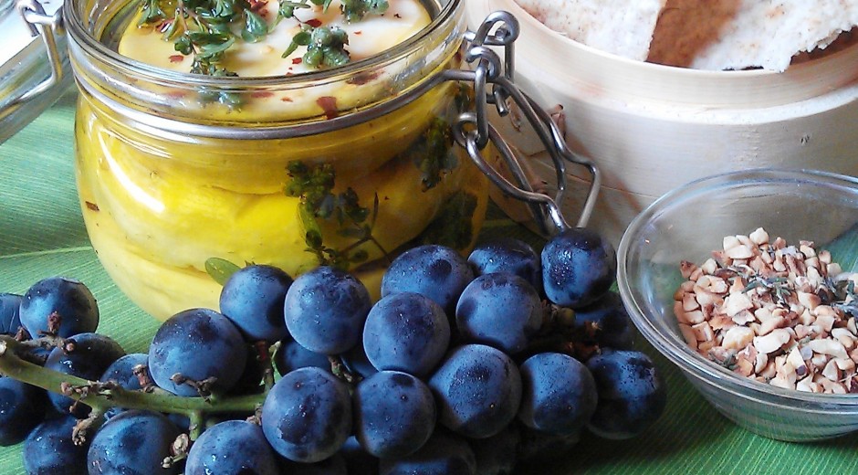 cup of cheese with herbs and bunch of grapes
