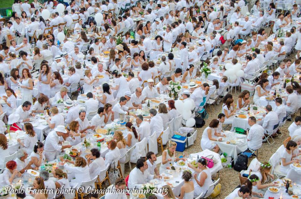 Cena in Bianco rows and rows of tables with people eating together all dressed in white in Turin