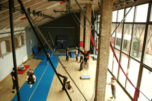 a unique experience in Turin is taking part in Cirko Vertigo - photo of studio with people training on equipment