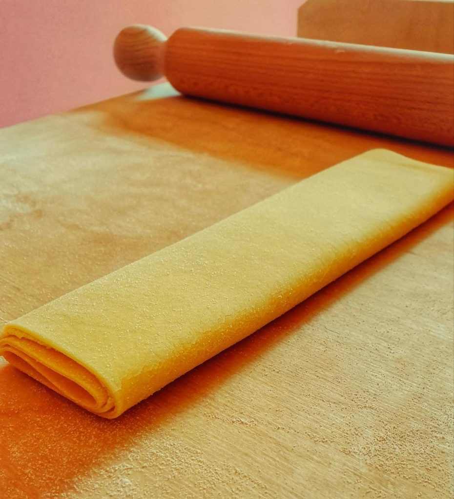 Tajarin pasta being rolled into a sheet before being cut for the tajarin recipe