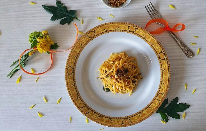Tajarin pasta served on a gold trimmed bowl. 